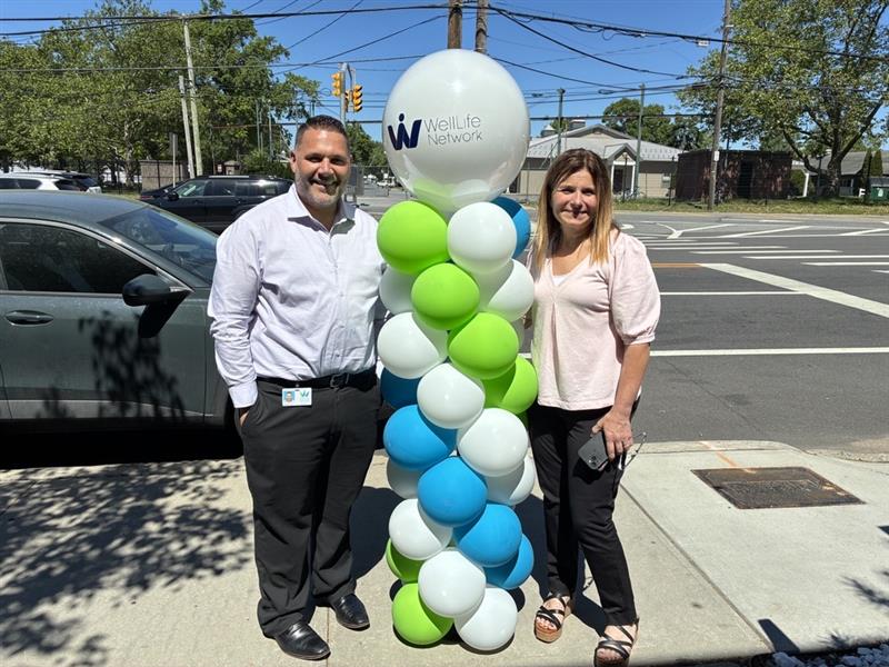 Two people standing with balloons